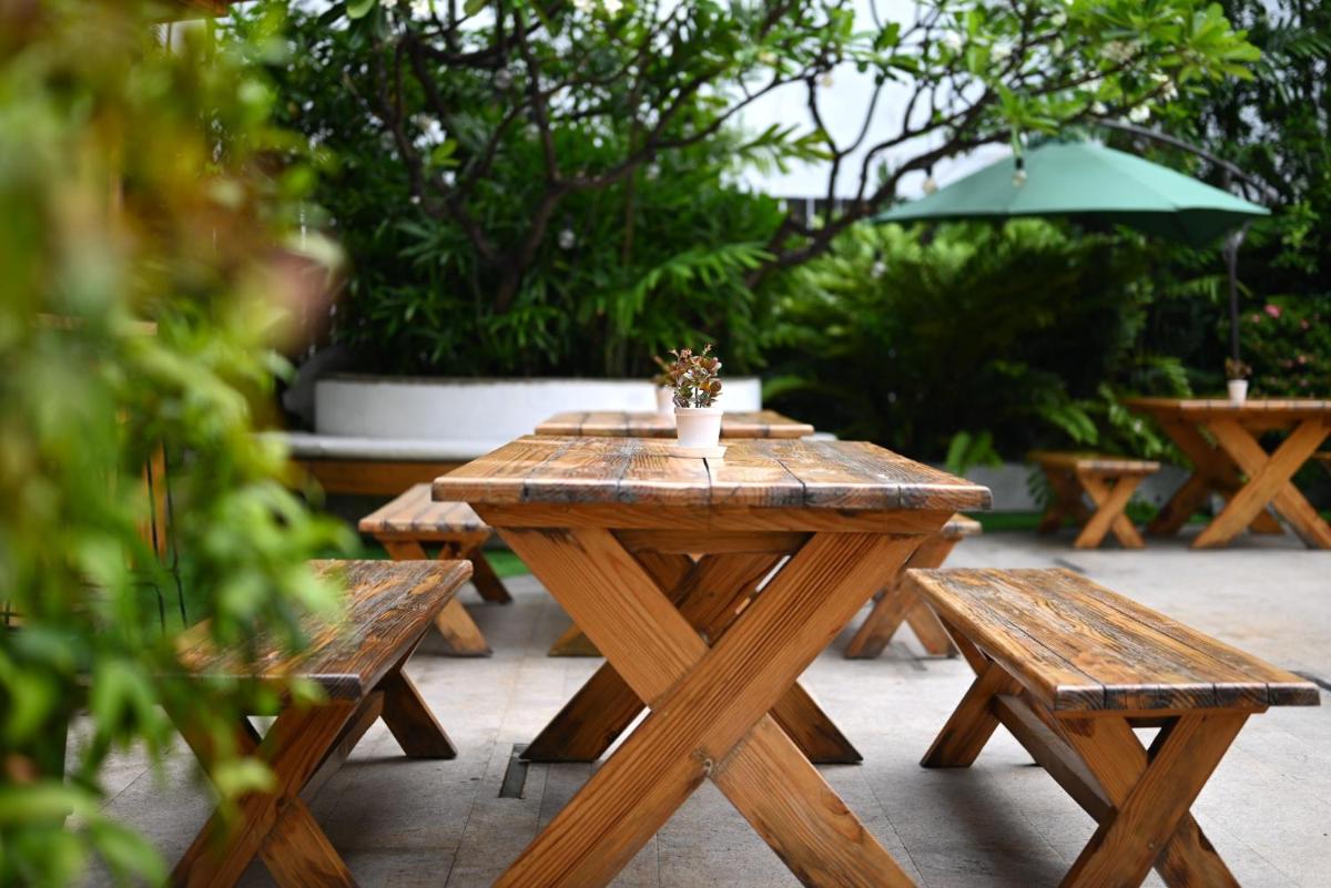 a wooden table with benches and a potted plant on it at The Park Kolkata in Kolkata