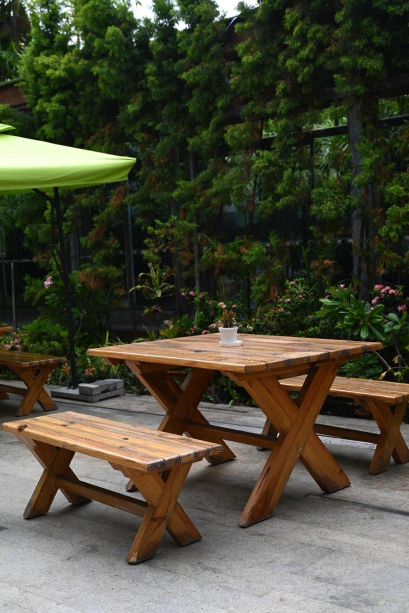 a picnic table and benches with a cup on top at The Park Kolkata in Kolkata