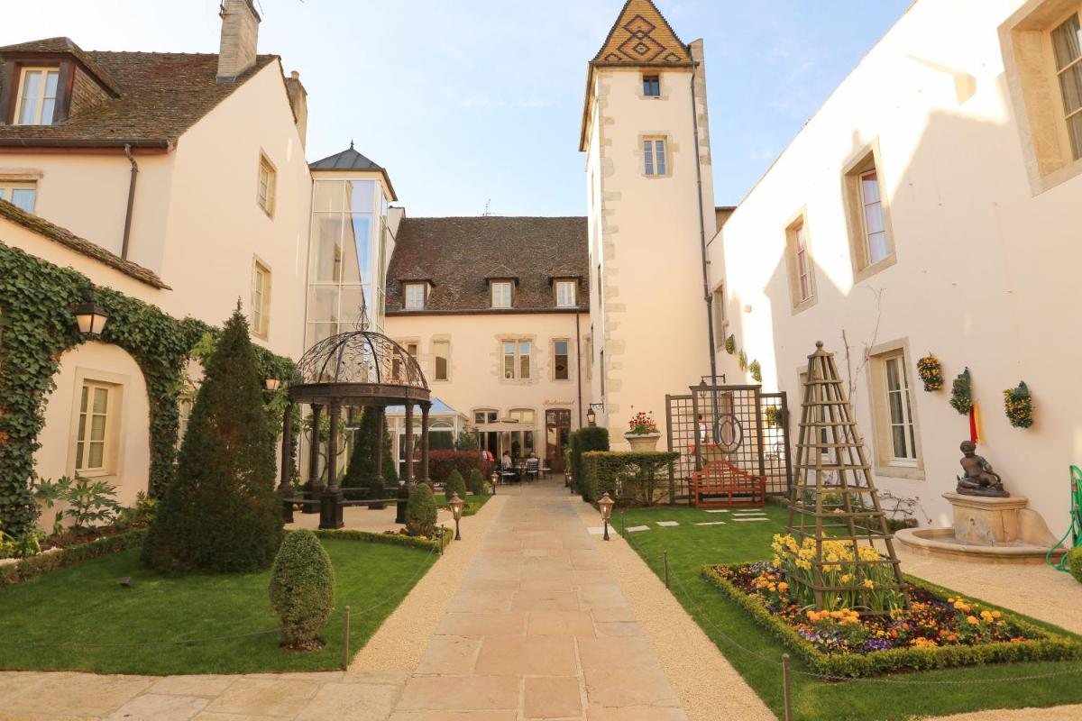 une cour intérieure d'un bâtiment avec une tour d'horloge dans l'établissement Hôtel Le Cep & Spa, à Beaune