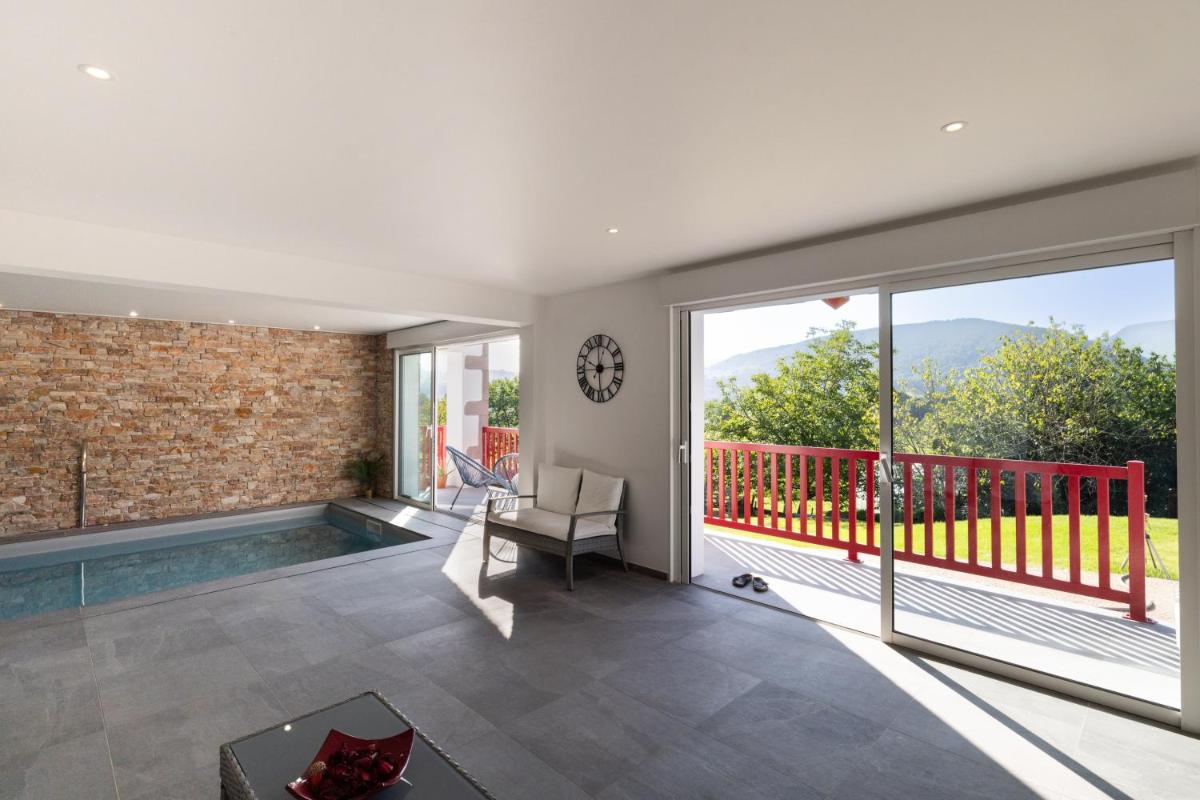 Il comprend un salon avec une piscine et un balcon. dans l'établissement Hotel Restaurant du Fronton - Maison Bonnet, à Itxassou