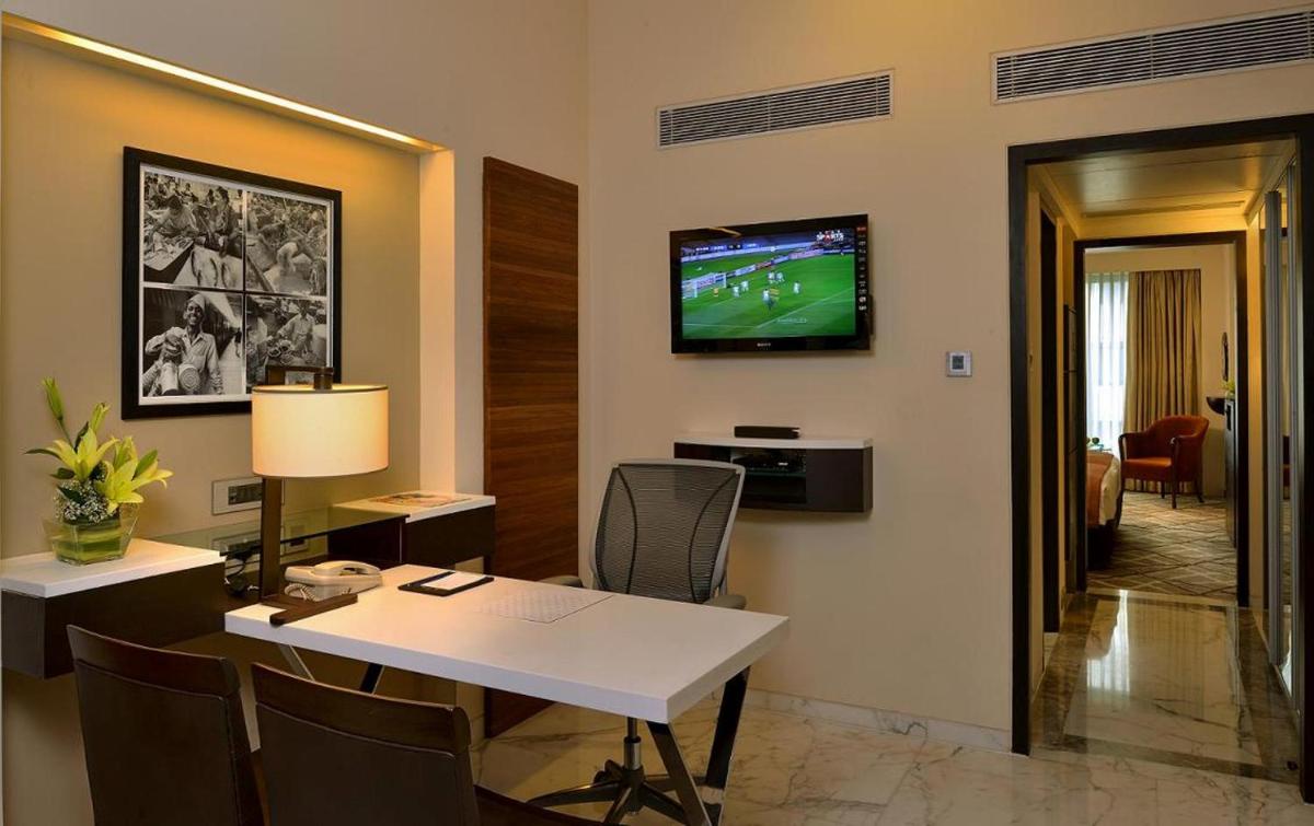 a room with a table and a television on a wall at Hotel Marine Plaza in Mumbai