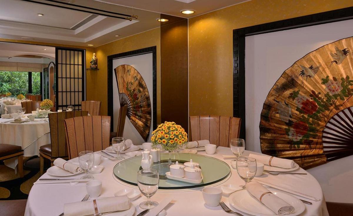 a dining room with a table with white plates and glasses at Hotel Marine Plaza in Mumbai