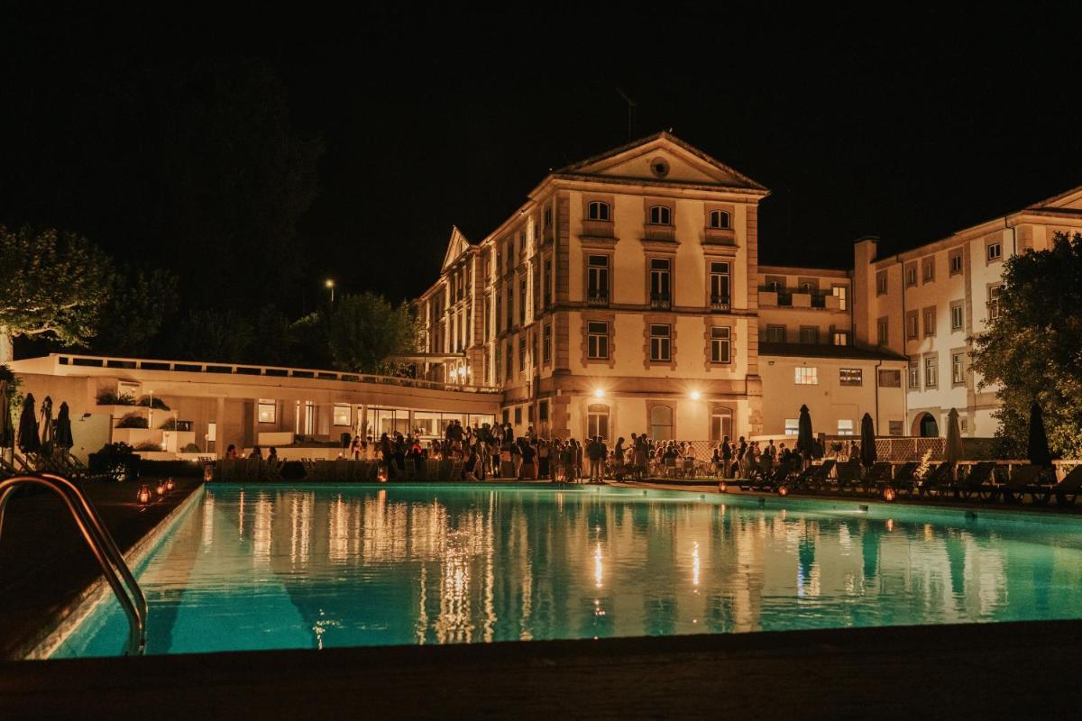 uma grande piscina em frente a um edifício à noite em Grande Hotel das Caldas da Felgueira nas Caldas da Felgueira