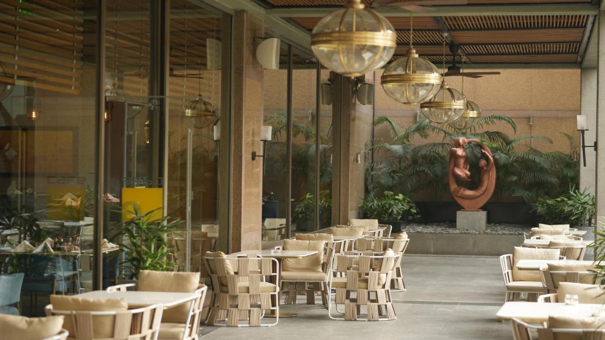 a restaurant with tables and chairs in a building at Crowne Plaza Today Gurugram by IHG in Gurgaon