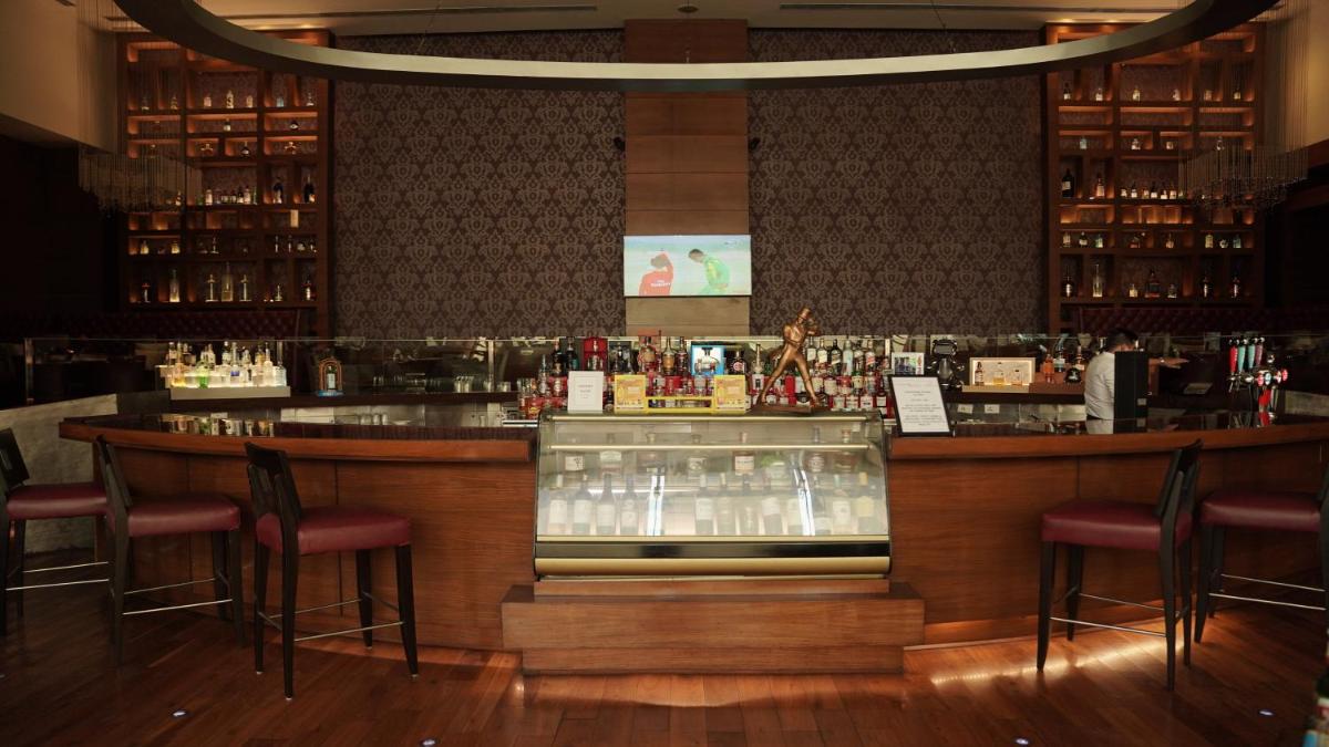 a bar in a restaurant with bar stools at Crowne Plaza Today Gurugram by IHG in Gurgaon
