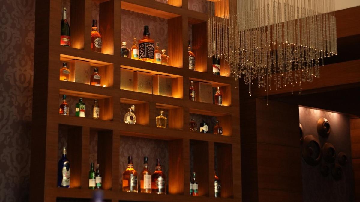 a bar with bottles of alcohol on a shelf at Crowne Plaza Today Gurugram by IHG in Gurgaon