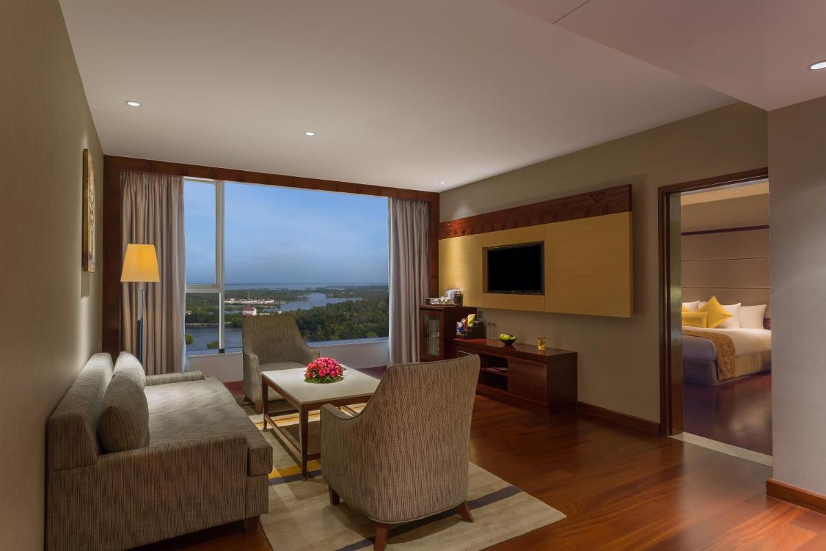 a living room with a couch and a table and a bed at Crowne Plaza Kochi by IHG in Cochin