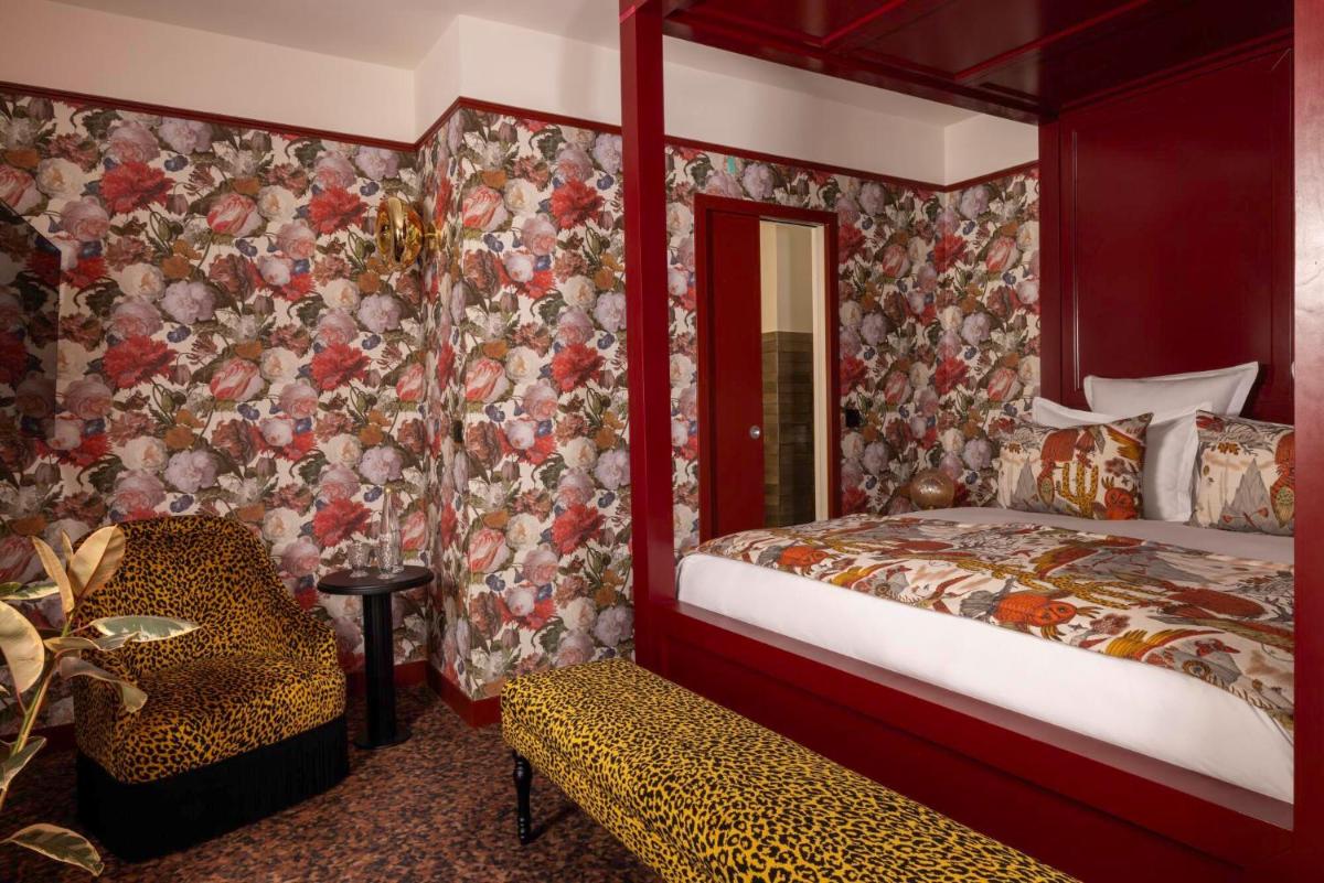 une chambre avec un lit et une chaise dans une pièce dans l'établissement Hôtel Ginette à la Folie & Spa, à Paris