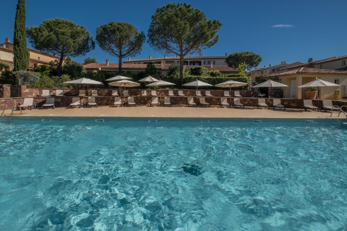 une piscine avec chaises et parasols dans l'établissement Les Appartements et Maisons du Domaine de Saint Endréol Golf & Spa Resort, à La Motte