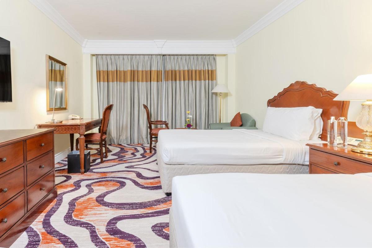 a hotel room with a bed and a desk at Le Royal Meridien Chennai in Chennai