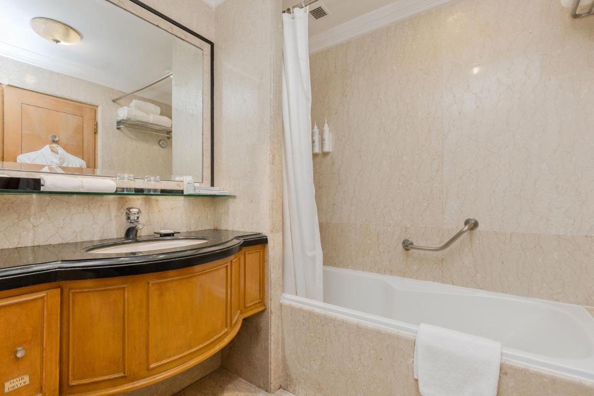 a bathroom with a tub and a sink and a shower at Le Royal Meridien Chennai in Chennai