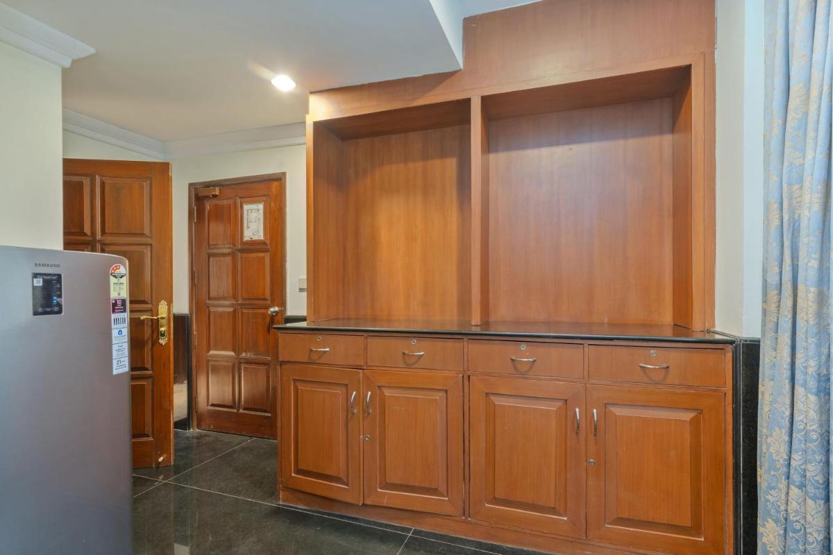 a kitchen with wooden cabinets and a refrigerator at Le Royal Meridien Chennai in Chennai