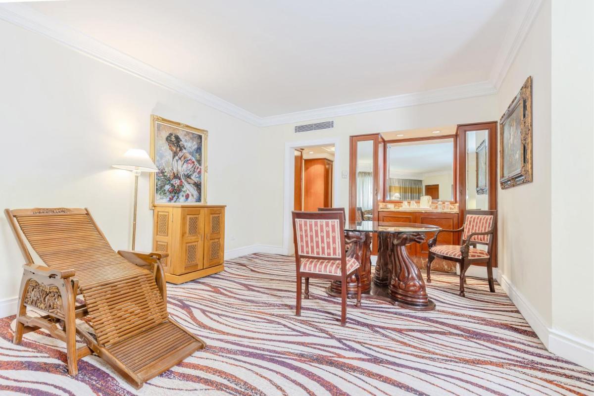 a living room with a table and chairs at Le Royal Meridien Chennai in Chennai