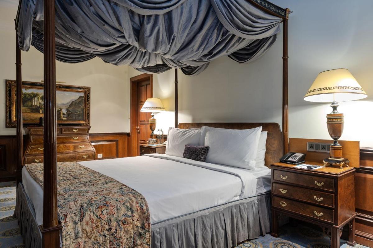 a bedroom with a canopy bed and a dresser at Le Royal Meridien Chennai in Chennai