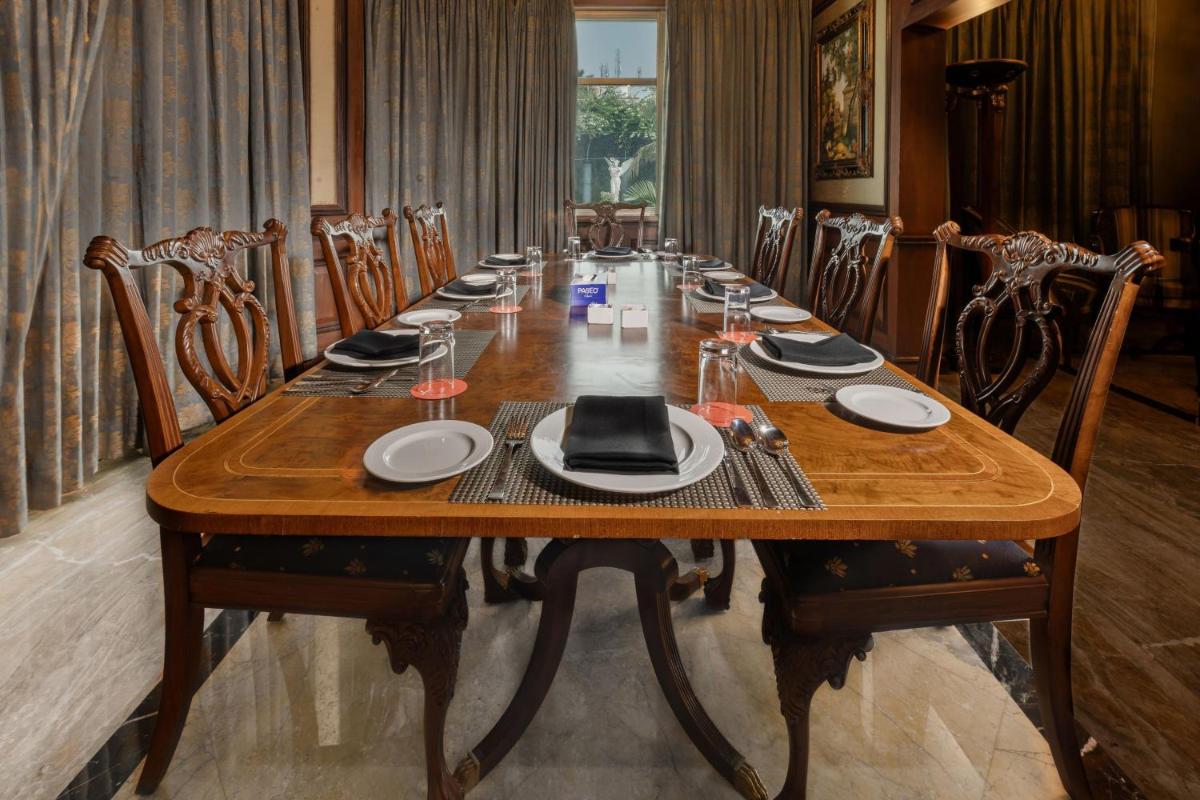 a long wooden table in a room with chairs at Le Royal Meridien Chennai in Chennai