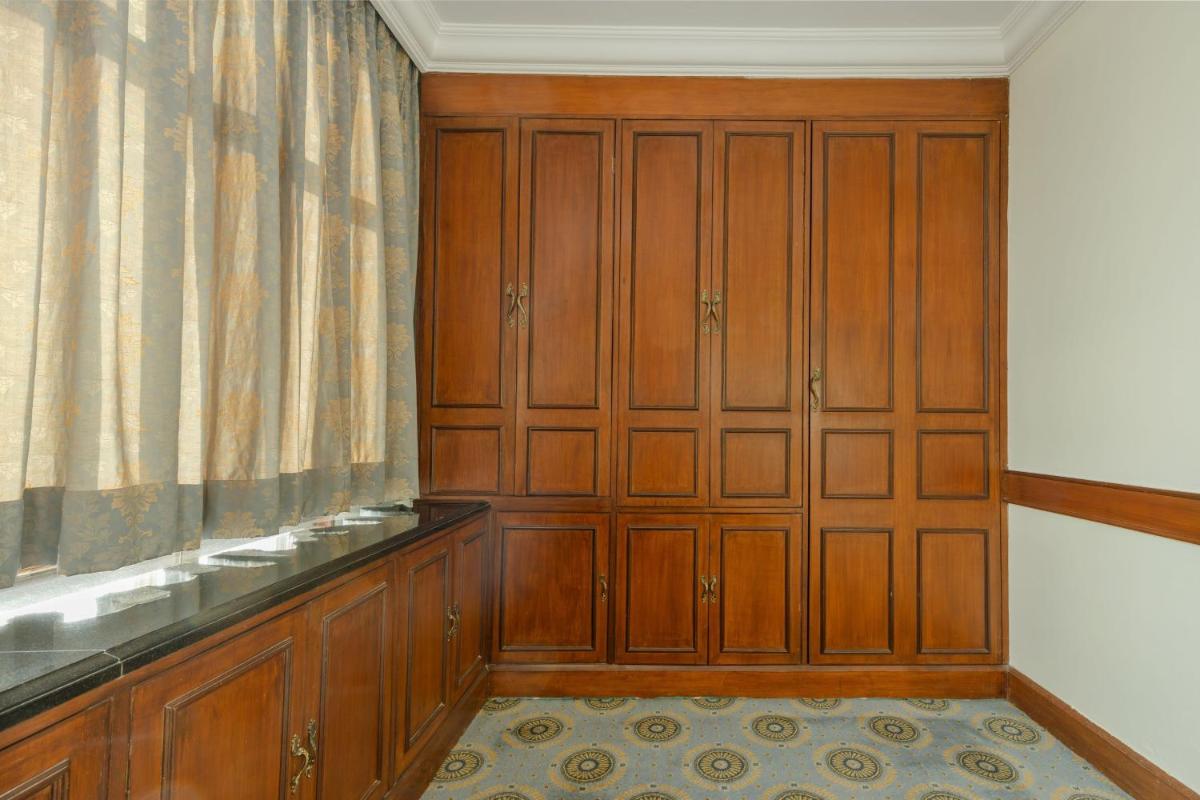 a room with wooden cabinets and a curtain at Le Royal Meridien Chennai in Chennai