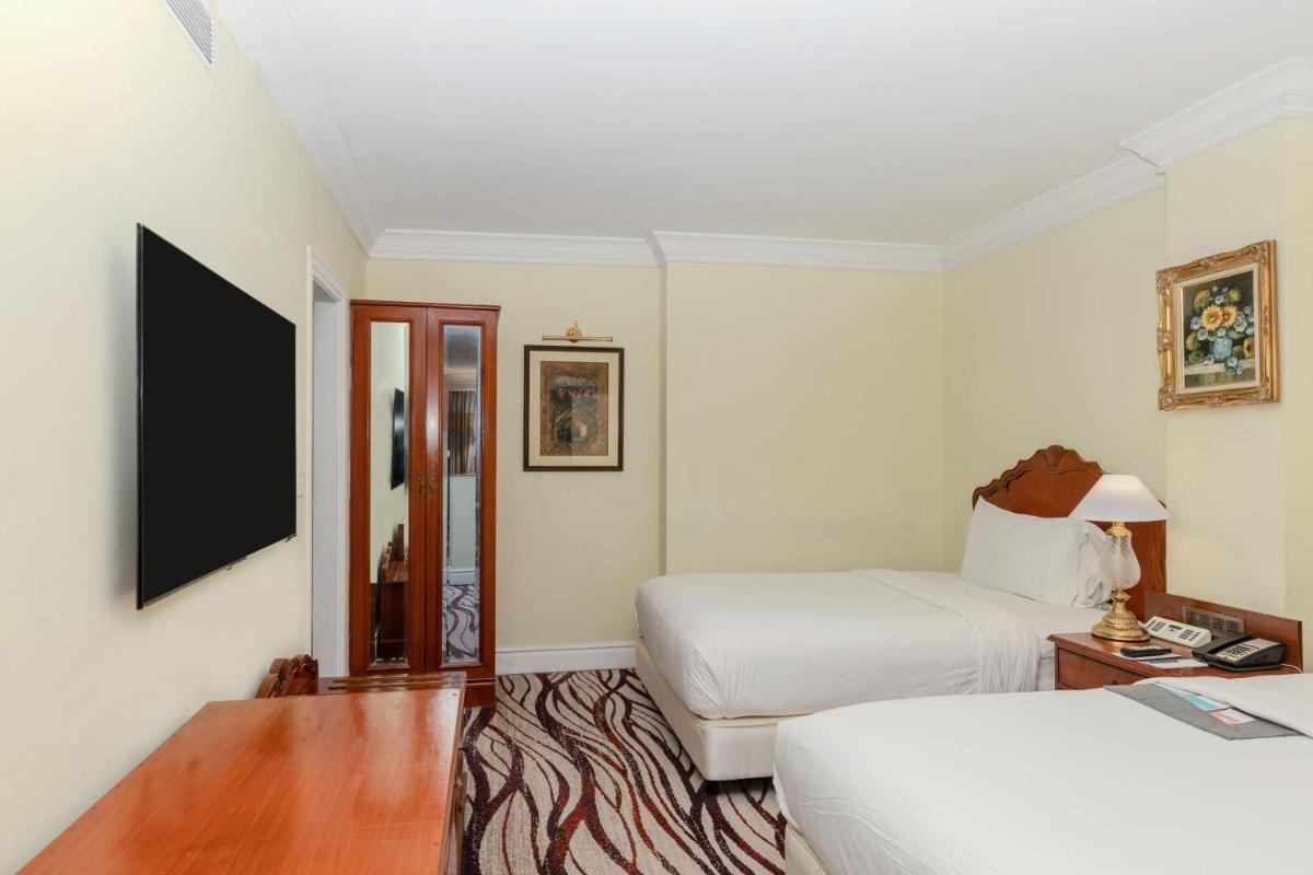 a hotel room with two beds and a tv at Le Royal Meridien Chennai in Chennai