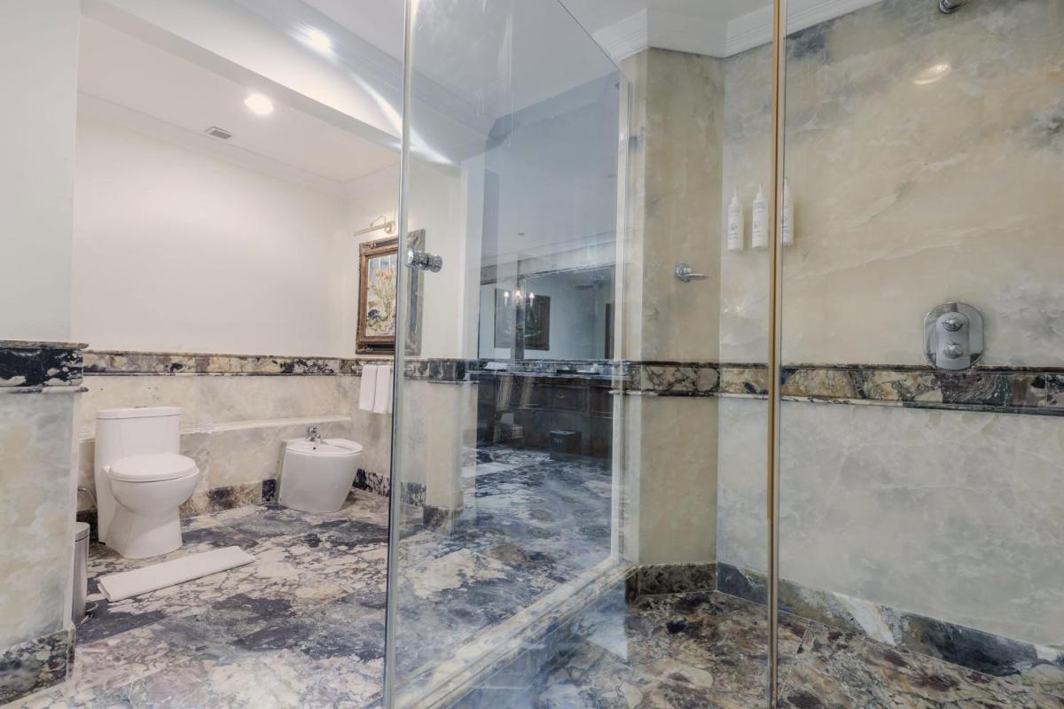 a bathroom with a glass shower and a toilet at Le Royal Meridien Chennai in Chennai