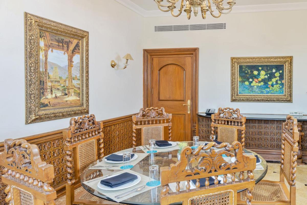 a dining room with a glass table and chairs at Le Royal Meridien Chennai in Chennai