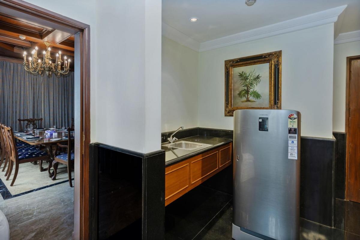 a kitchen with a refrigerator and a dining room at Le Royal Meridien Chennai in Chennai