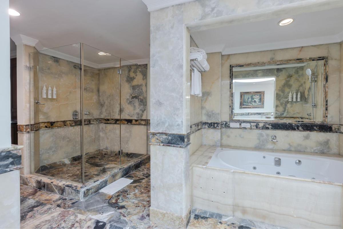 a large bathroom with a tub and a shower at Le Royal Meridien Chennai in Chennai