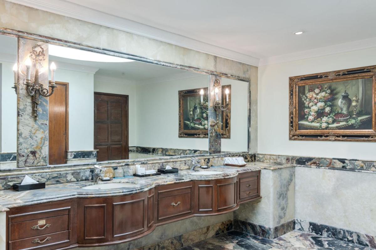 a bathroom with two sinks and a large mirror at Le Royal Meridien Chennai in Chennai