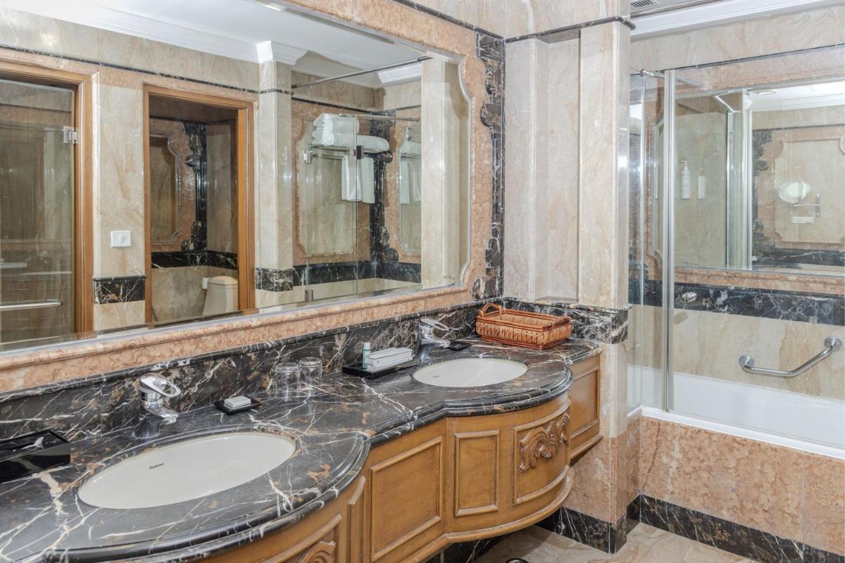 a bathroom with two sinks and a shower at Le Royal Meridien Chennai in Chennai