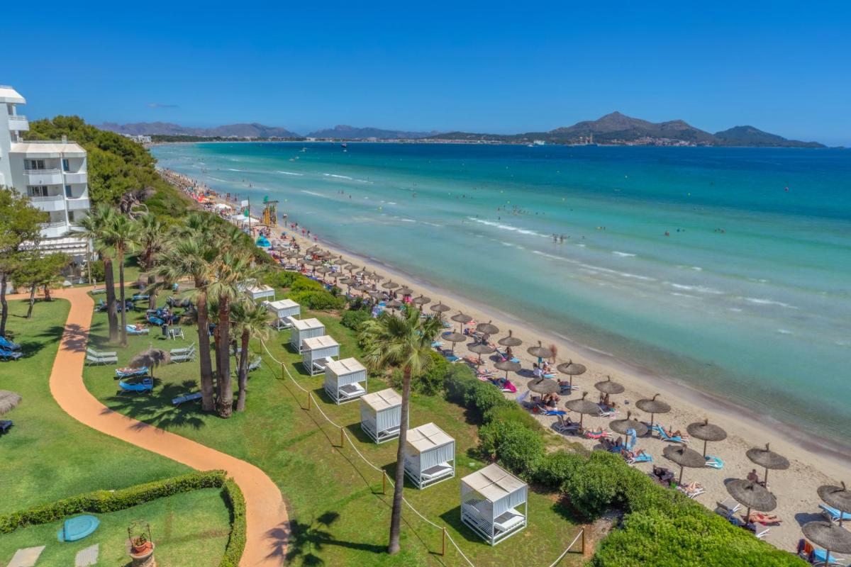 Una vista aérea de una playa con sombrillas y el océano. en Playa Esperanza Resort Affiliated by Meliá, en Playa de Muro