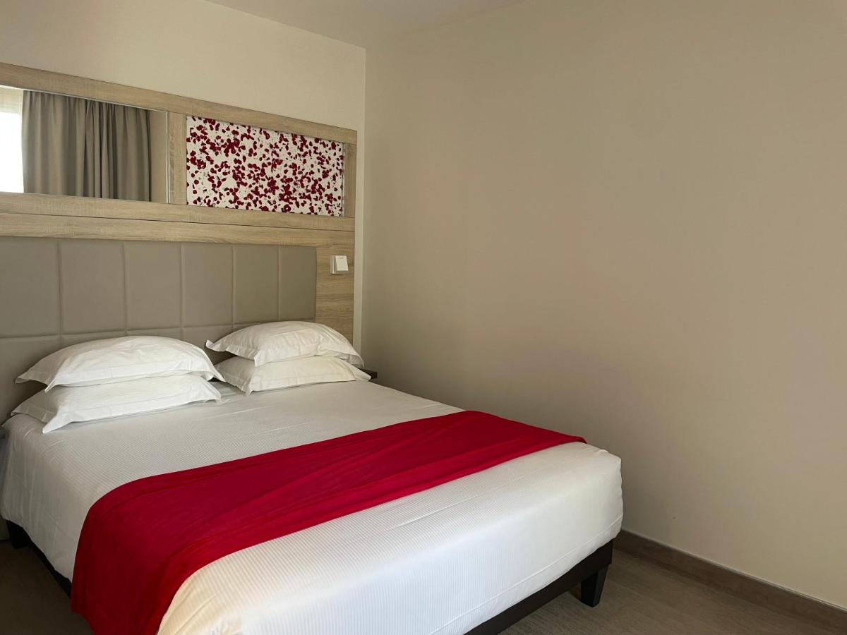 Un ou plusieurs lits dans un hébergement de l'établissement Brit Hotel de Grignan Vichy