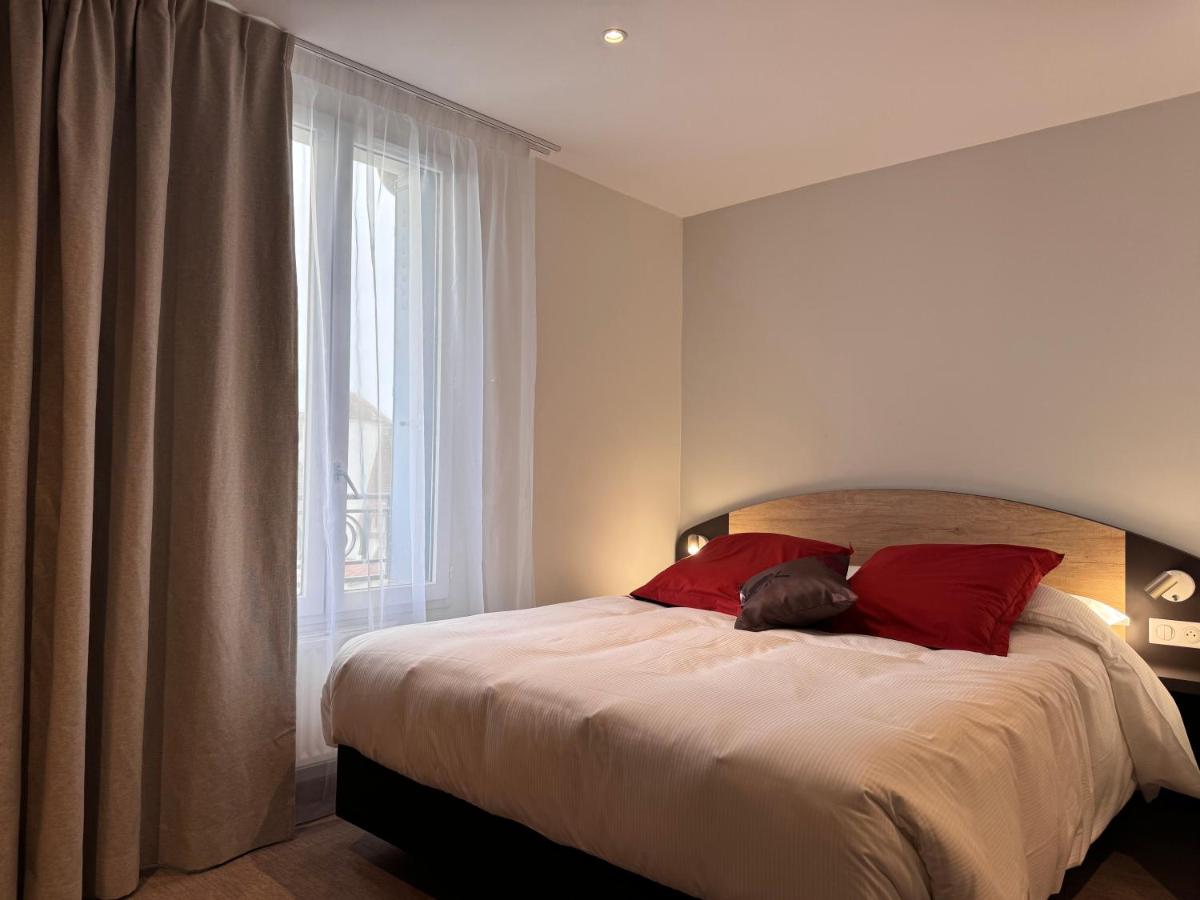 Un ou plusieurs lits dans un hébergement de l'établissement Brit Hotel de Grignan Vichy
