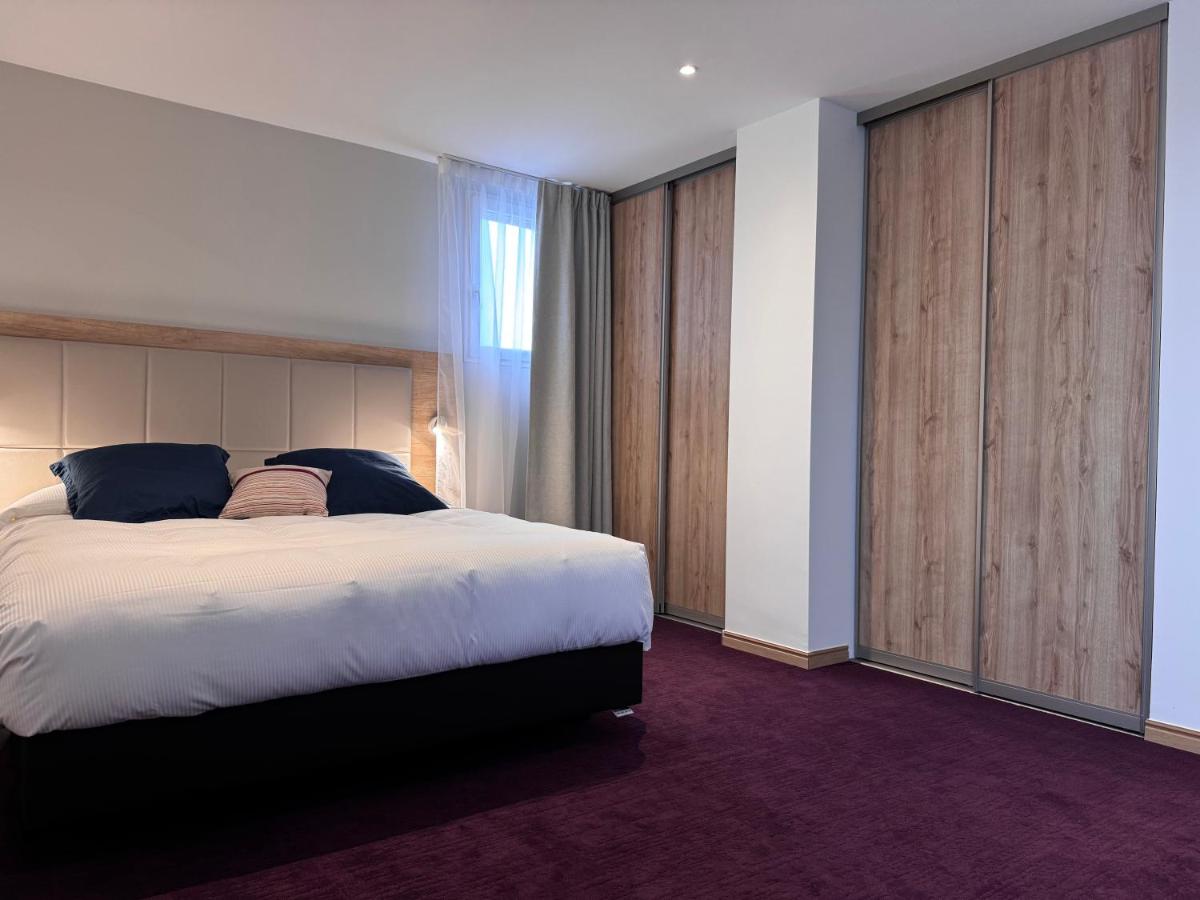Un ou plusieurs lits dans un hébergement de l'établissement Brit Hotel de Grignan Vichy