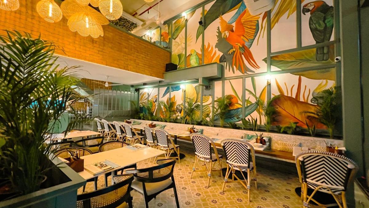 a restaurant with tables and chairs and a mural at Holiday Inn Chennai OMR IT Expressway by IHG in Chennai