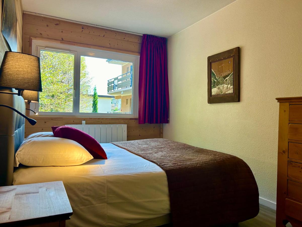 une chambre avec un grand lit et une fenêtre dans l'établissement Résidence Côté Chalet, à Thonon-les-Bains