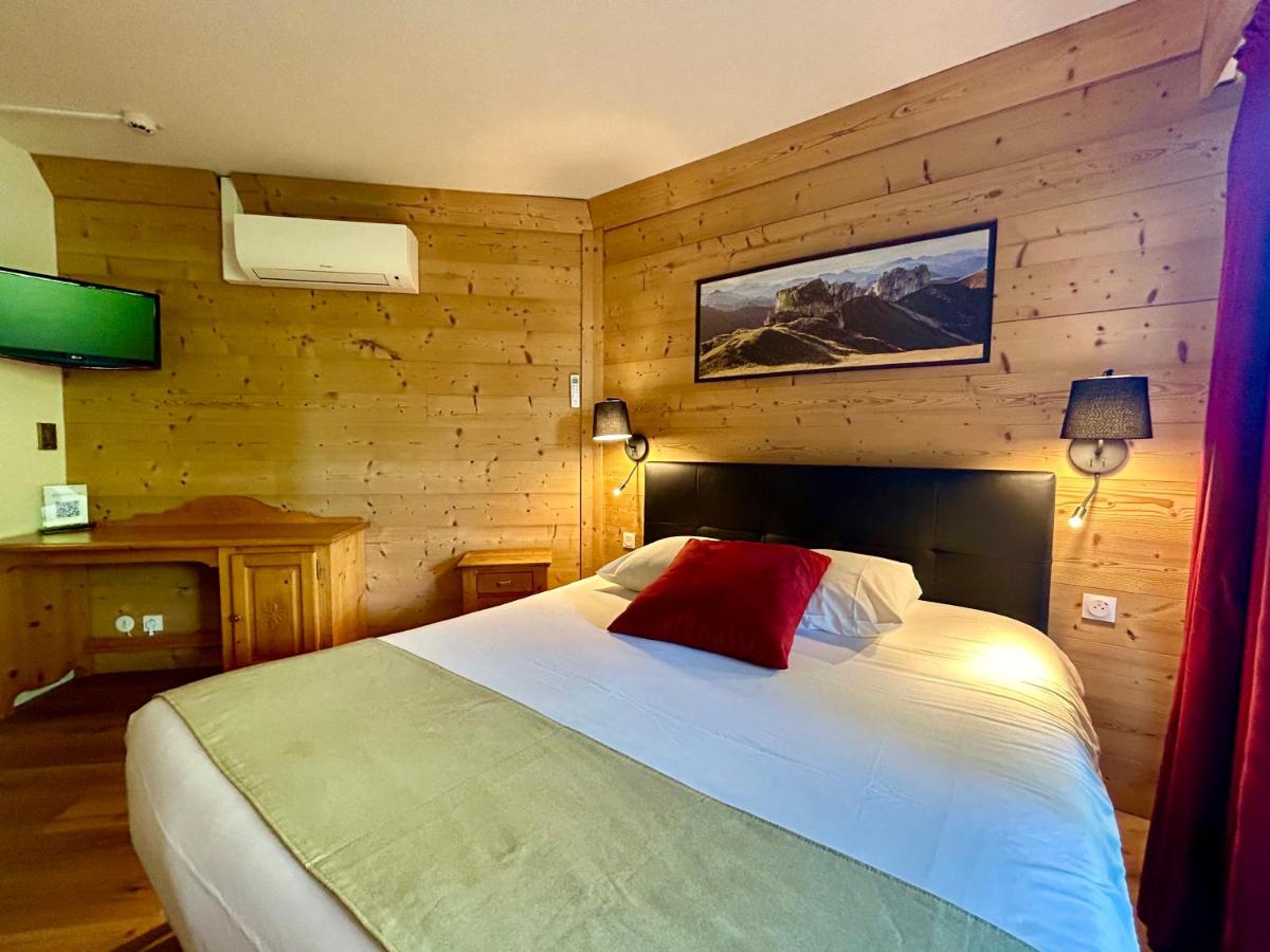 une chambre avec un lit avec un oreiller rouge dessus dans l'établissement Résidence Côté Chalet, à Thonon-les-Bains