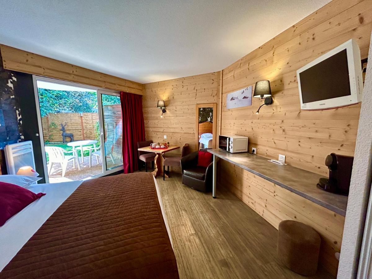 une chambre d'hôtel avec un lit et une télévision au mur dans l'établissement Résidence Côté Chalet, à Thonon-les-Bains