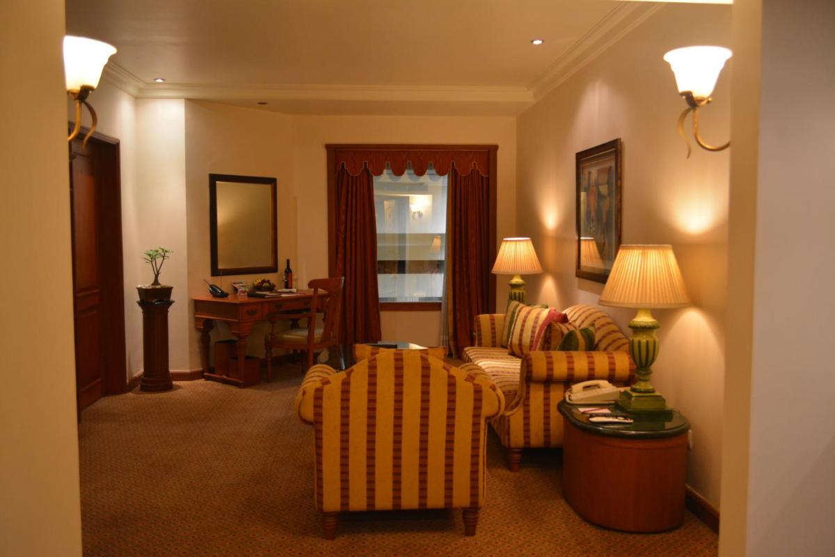 a living room with a couch and chairs and a table at The Orchid Hotel Mumbai Vile Parle in Mumbai