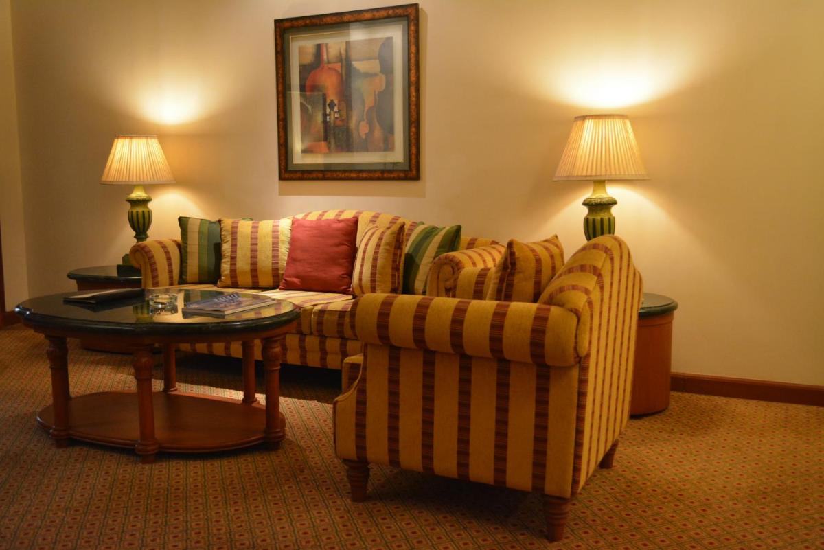 a living room with a couch and a table at The Orchid Hotel Mumbai Vile Parle in Mumbai