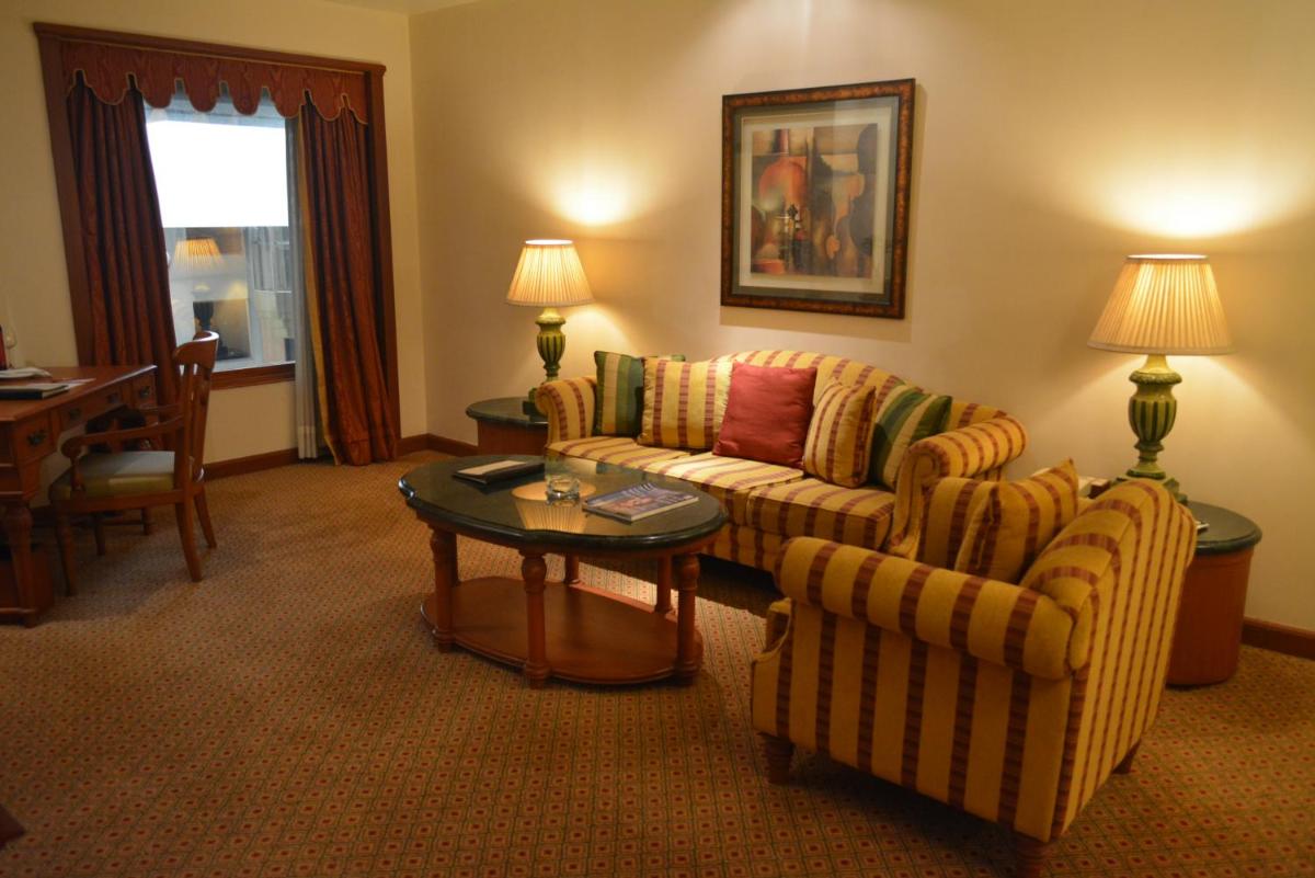 a living room with a couch and chairs and a table at The Orchid Hotel Mumbai Vile Parle in Mumbai