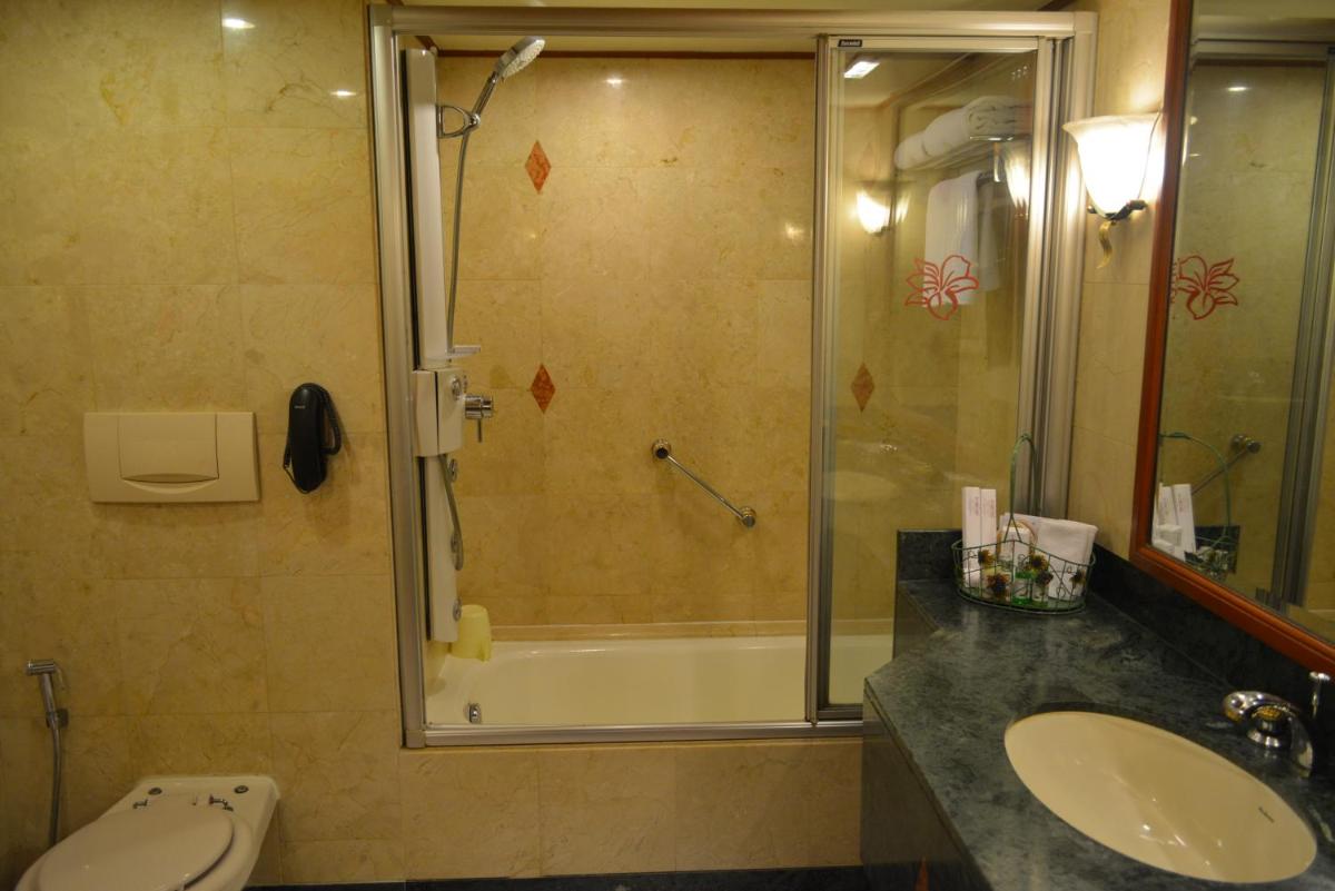 a bathroom with a shower and a sink and a toilet at The Orchid Hotel Mumbai Vile Parle in Mumbai