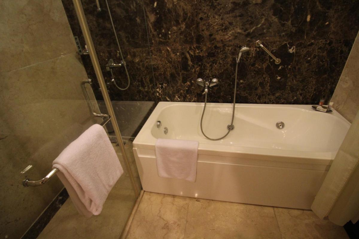 a bathroom with a bath tub and a shower at Fortune Select JP Cosmos, Bengaluru - Member ITC Hotels' Group in Bengaluru