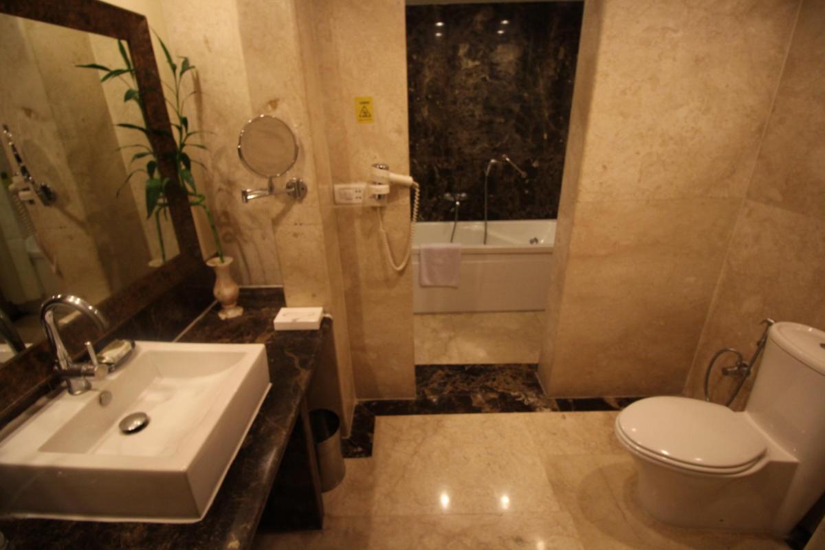 a bathroom with a sink and a toilet and a tub at Fortune Select JP Cosmos, Bengaluru - Member ITC Hotels' Group in Bengaluru