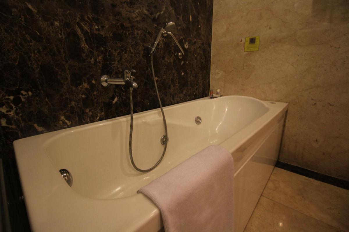 a bathroom with a bath tub with a towel on it at Fortune Select JP Cosmos, Bengaluru - Member ITC Hotels' Group in Bengaluru