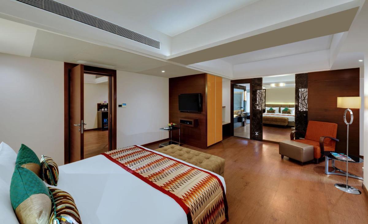 a hotel room with a bed and a living room at The Fern Kadamba Hotel And Spa in Old Goa