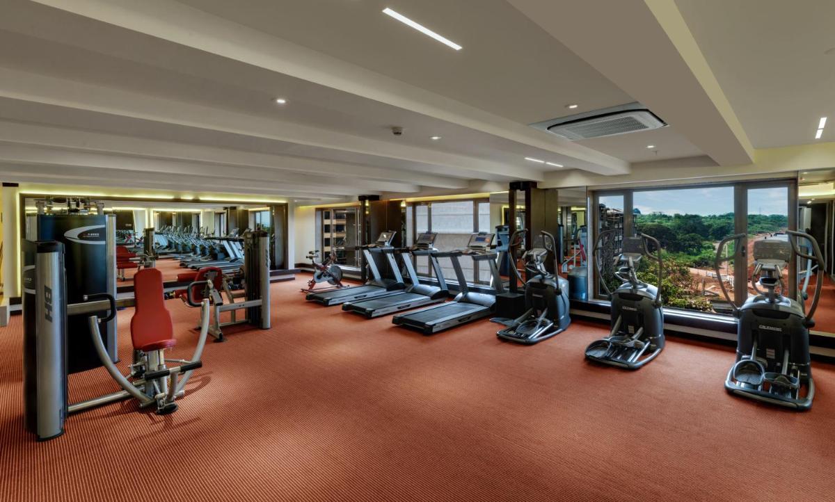 a gym with treadmills and elliptical machines at The Fern Kadamba Hotel And Spa in Old Goa