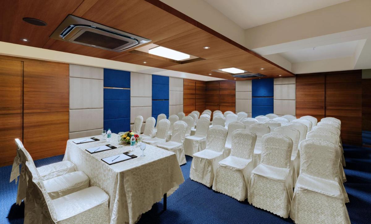 a conference room with white chairs and tables in it at The Fern Kadamba Hotel And Spa in Old Goa