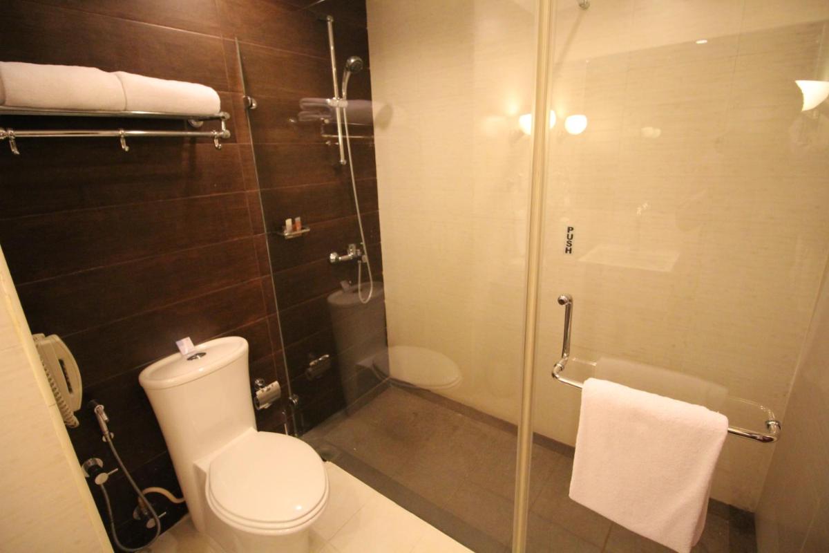 a bathroom with a toilet and a glass shower at Fortune Select JP Cosmos, Bengaluru - Member ITC Hotels' Group in Bengaluru