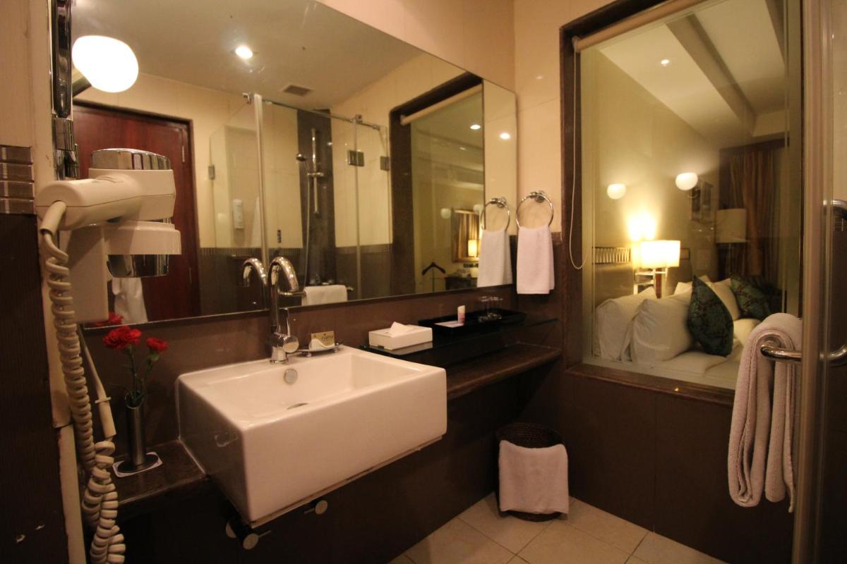 a bathroom with a sink and a large mirror at Fortune Select JP Cosmos, Bengaluru - Member ITC Hotels' Group in Bengaluru
