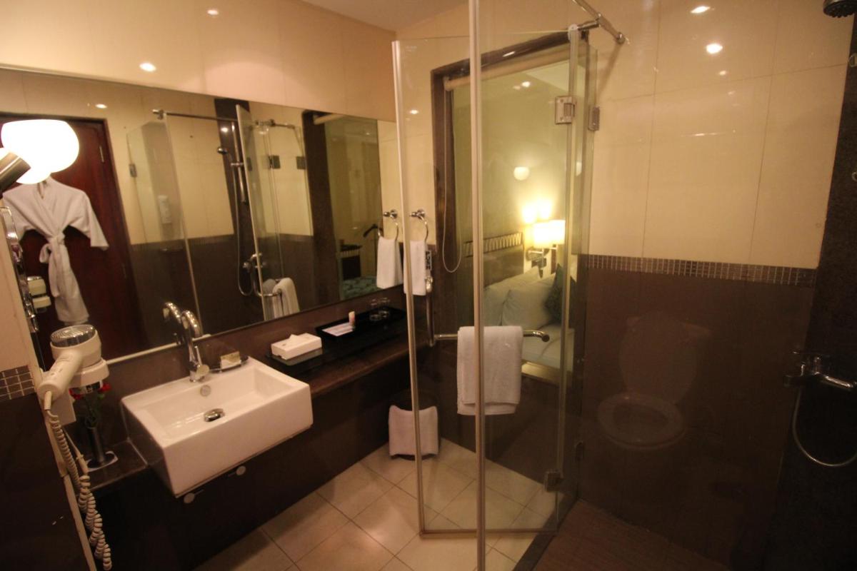 a bathroom with a sink and a glass shower at Fortune Select JP Cosmos, Bengaluru - Member ITC Hotels' Group in Bengaluru