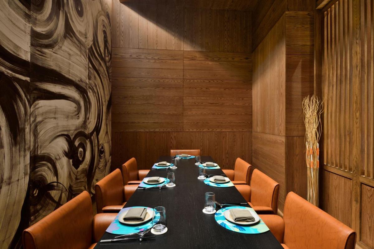 a dining room with a long table and chairs at The Westin Mumbai Powai Lake in Mumbai
