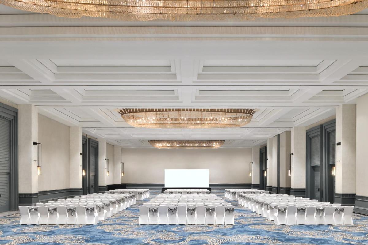 a ballroom with rows of white tables and chairs at The Westin Mumbai Powai Lake in Mumbai